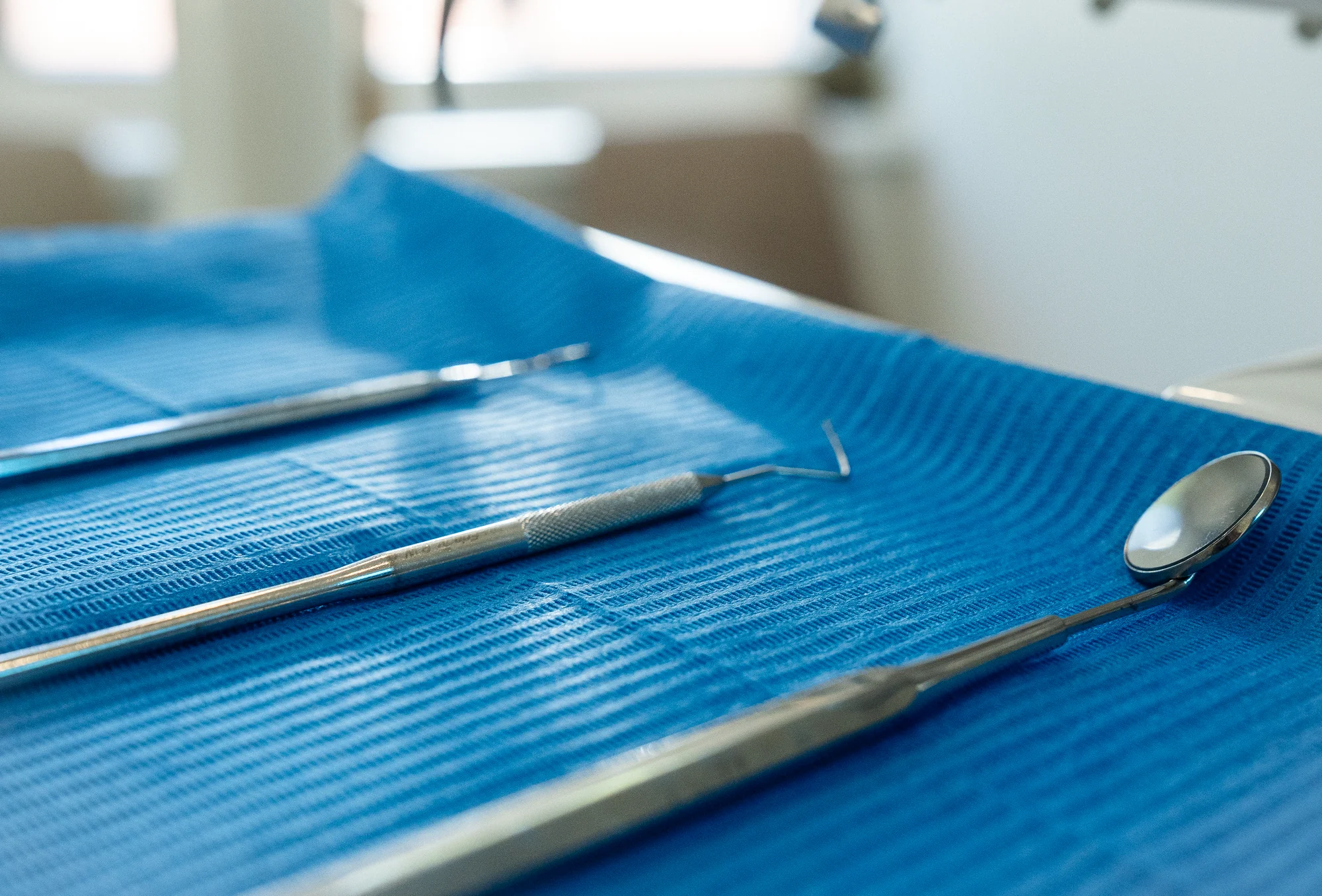 Mondspiegel en tandartsinstrumenten op een blauwe doek